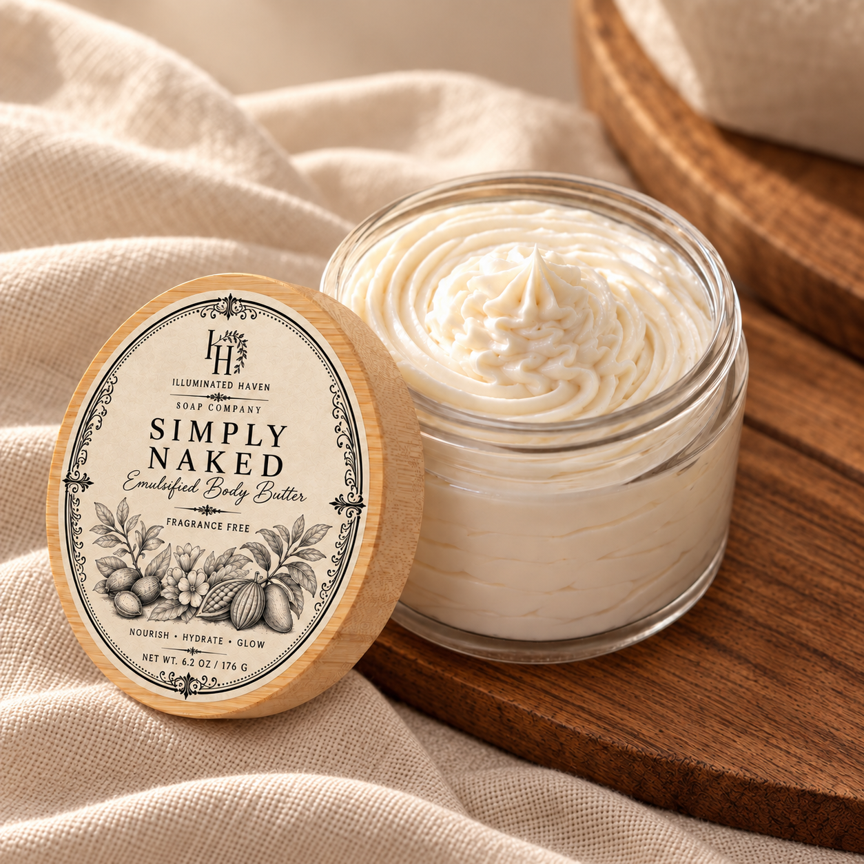 Simply Naked fragrance-free emulsified body butter on linen beside a bamboo lid