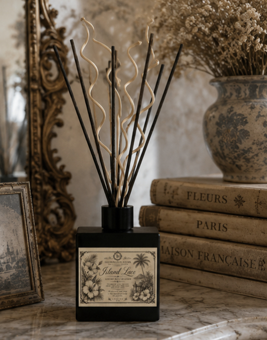 Close-up of Island Lace Reed Diffuser label with ornate botanical illustration on matte black glass